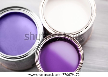 Several opened cans with paint inside. Ultra Violet and white colors of paint. Close up. Royalty-Free Stock Photo #770679172