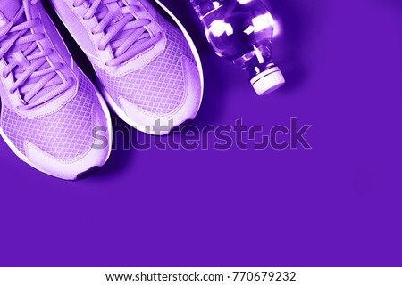 Ultra Violet sneakers and bottle of water on purple background. Concept of healthy lifestile, everyday training and force of will. Royalty-Free Stock Photo #770679232