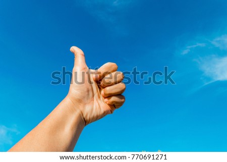 Sign of hand with blue cloudy sky background.