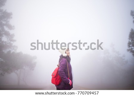 Young Asian woman traveling at mountain amidst the heavy fog, Beautiful nature in Thailand.