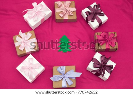 Gift boxes tied with satin coloured ribbon on a pink background. Gifts in boxes for the holiday. Top view flat lay