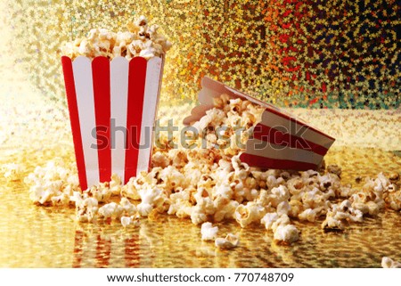 Paper cup in red and white with popcorn on color background