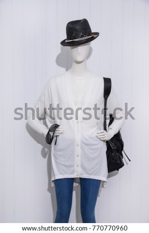 female shirts with hat in jeans with handbag sunglasses on mannequin- wooden background
