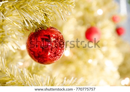 Red Christmas ball hanging on Gold Christmas Tree