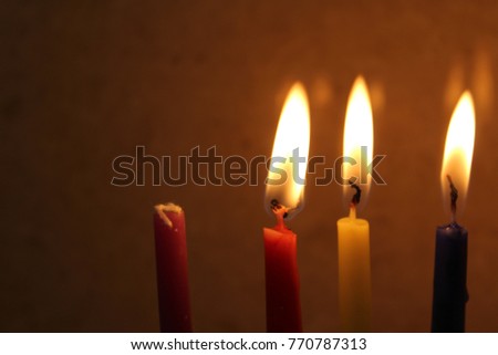 Colorful Chanukah candles lit in the menorah