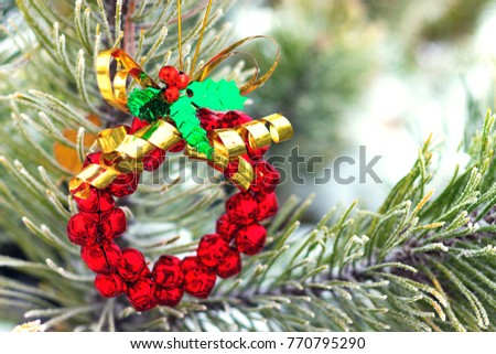 Christmas wreath made from red bells on a fir tree, winter day