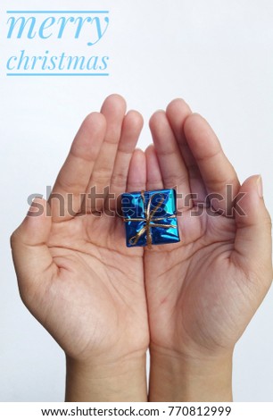 concept image of mini gift blue colour on the hand and word - Merry Christmas with white background.