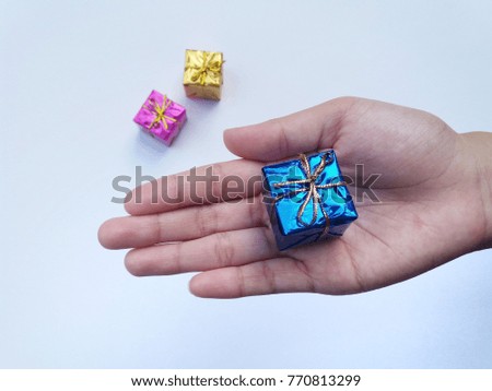 concept image of mini gift blue colour on the hand with white background.