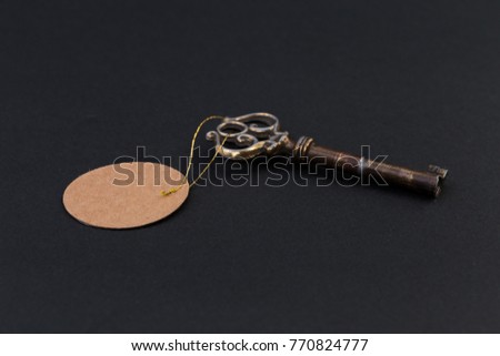 Old house key with blank tag or label on black background