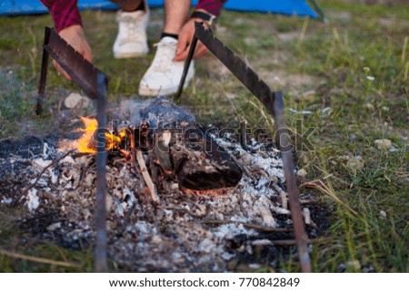 Burning wood bonfire in brazier outdoor. Flames fire BBQ in nature. Preparation for cooking barbecue outside, summertime. Tourism, hiking concept. Close up photo. 