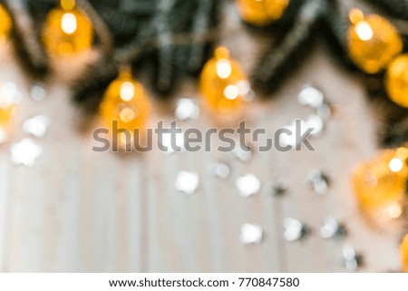 Christmas blurred background with a glowing garland golden bokeh on white wooden table. A beautiful holiday idea for postcards and posters. Free space, frame