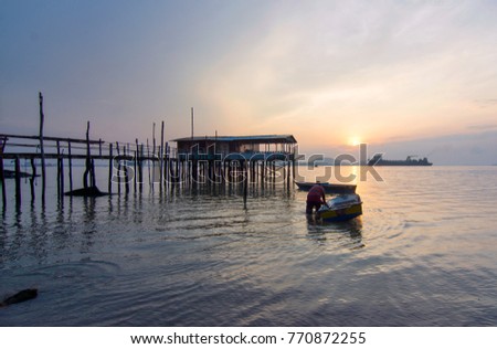 Sunrise at beach with fisherman boat parking and old jetty . Tanjung Langsat JohorThe image may have soft, blurry and noise due to long exposure