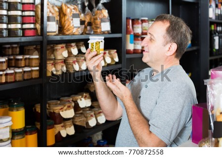 Mature man looking at assortment of grocery products in shelves