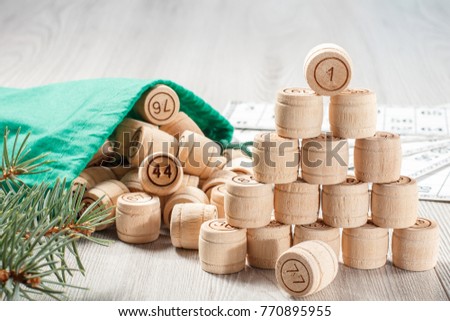 Board game lotto. Stacked wooden lotto barrels with bag, game cards for a game in lotto and Christmas fir tree branches