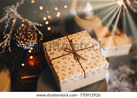 Beautiful wrapped box under decorated Christmas tree. Festive event. Prepared surprise. Celebration and holidays concept. New Year home decoration. Handmade Christmas present