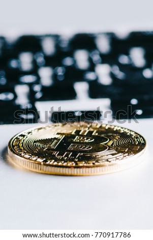 bitcoin coin on a white laptop keyboard