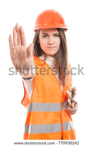 Worker woman making stop sign with her palm wearing protection equipment at job