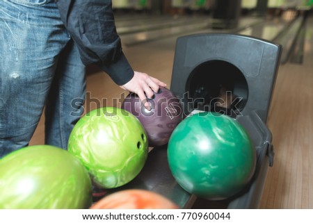 The hands of the man chosen ball for bowling. Color balls for bowling.