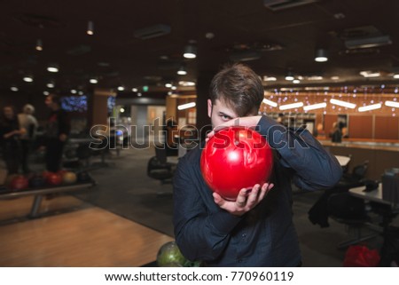 A man in a black shirt holds a bowl for his face and looks and looks for him.