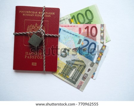 Russian passport wrapped in a chain with a lock on the background of Euro banknotes. Passport, a castle and money.