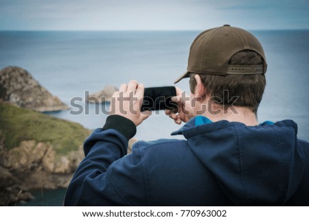 Man Taking picture with his cell from a pretty view