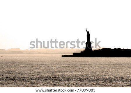 The New York harbor on a hazy day with a silhouette of the statue of liberty in the background - sepia tone.