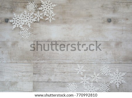 White paper snowflakes on wooden background with copy space, christmas and new year, minimalistic design	