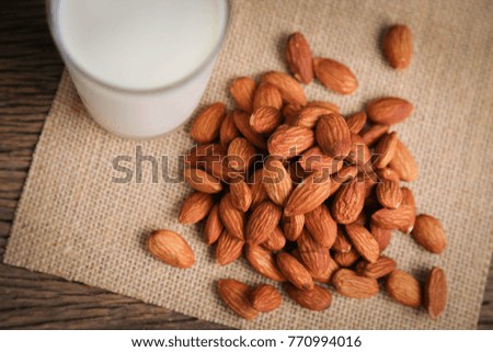Almonds and fresh milk on wood background