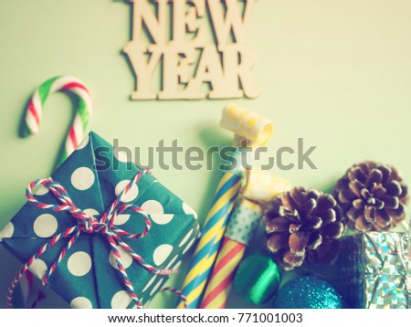 Pastel green NEW YEAR background with candy cane, gift boxes, noisemakers, pine cones and Christmas ball. Concept image for special days in New Year 2018. (Top view, selective focus, vintage filter)