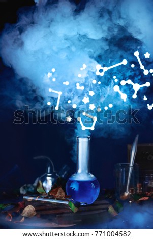 Potion bottle with steam and constellations. Still life with magical equipment and starry sky. Astronomer workplace