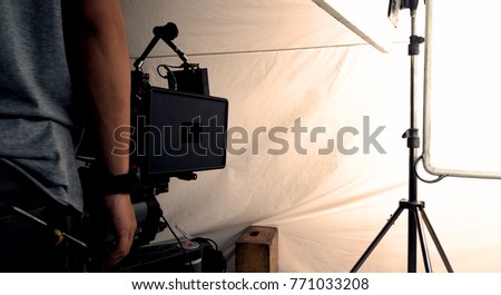 Behind the scenes of shooting video or movie production crew team and silhouette of camera and equipment in studio. 