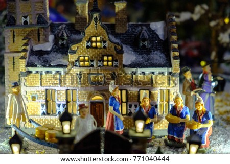 Miniature of winter dutch scene with Christmas houses, people, trees, cheese, Christmas concept.