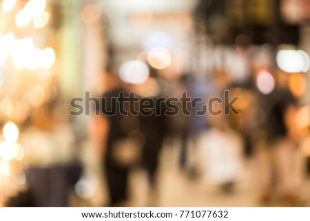blurred of crowd people walking in shopping mall with lighting and bokeh.