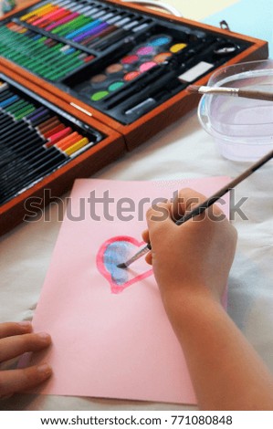 Child painting homemade greeting card