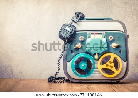 Retro old reel to reel tape recorder and headphones front concrete wall background. Vintage instagram style filtered photo Royalty-Free Stock Photo #771108166