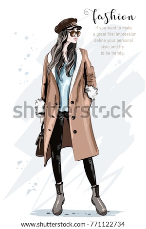 Fashion model posing. Stylish beautiful woman in coat and cap. Hand drawn fashion woman. Sketch. Vector illustration. Royalty-Free Stock Photo #771122734