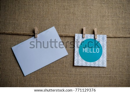 Hanged note paper with hello text with blank paper - sackcloth background