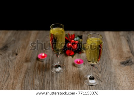 glasses of champagne and Christmas ornaments on dark wooden background
