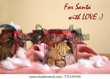 Homemade Christmas cookies in a jar arranged on a beige - pink cloth