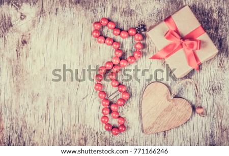 Festive decorations for Valentine's Day. Gift box with bow, beads and wooden heart.Copy space