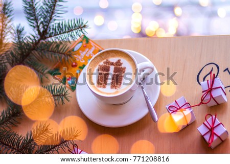 Christmas coffee in a white cup with a gift picture on white foam