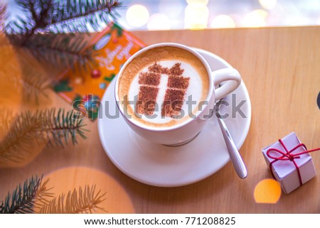 Christmas coffee in a white cup with a gift picture on white foam