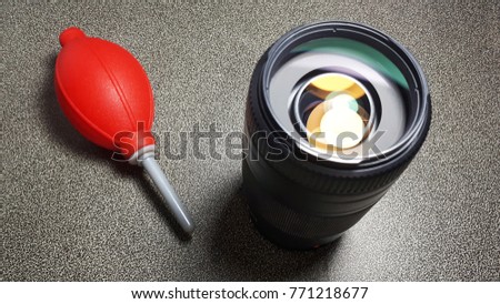 Cleaning lens of DSLR camera by air blower, focus at lens