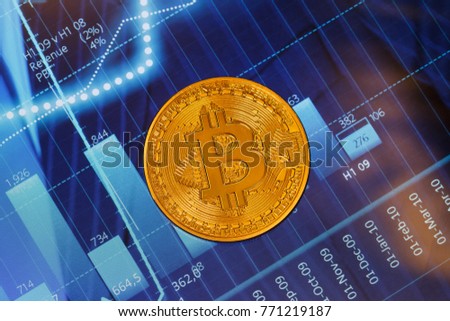 Golden bitcoin coin are stacked on a bright background of business graphs close-up. New virtual money concept cryptocurrency.