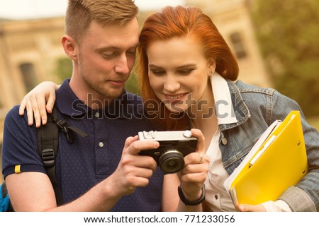 Shot of a happy college couple looking at the photos on the camera while outdoors on campus photography photographer digital vintage retro camera instant love couples dating relationships
