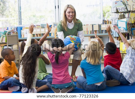Teacher in class showing students a globe Royalty-Free Stock Photo #77123326