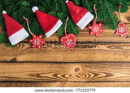 Holiday background with Santa hats and traditional Christmas decoration on old wood