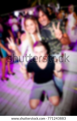 Blurred for background. night club party. People during concert in night club party. Blurred Crowd People. Abstract blurry festival event with beautiful lights decoration inside night club background