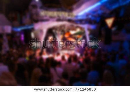 Blurry night club dj party people enjoy of music dancing sound with colorful light. club night light dj party. With Smoke Machine and lights. Dark colored background
