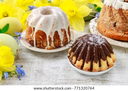 Traditional easter cakes and bouquet of daffodils in the background.